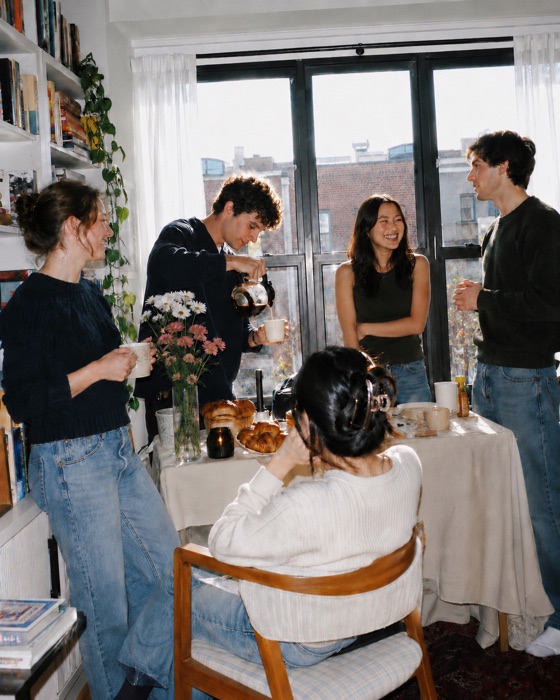 Friends sharing coffee and pastries at an apartment cafe