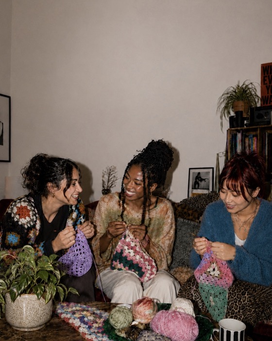 Friends knitting together in a living room