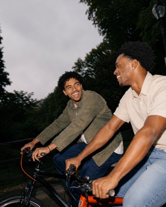 Two friends laughing during an evening bike ride